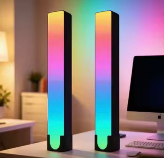Two tall, rectangular LED lights with RGB color change on a desk.